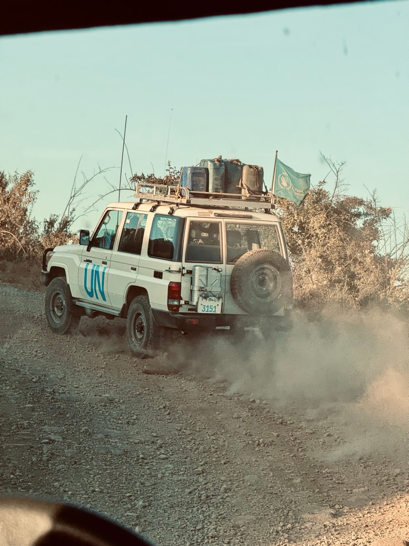 A white UN Land Cruiser loaded with gear kicks up dust on a mountain track in northern Ethiopia