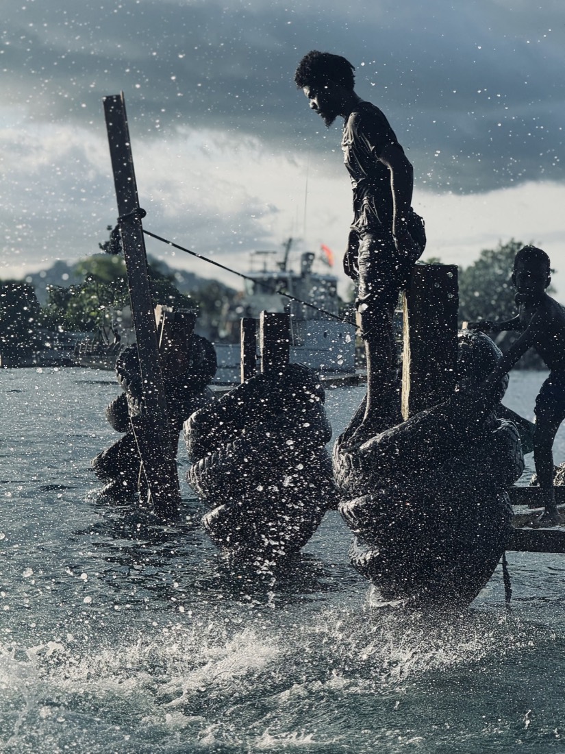 Figures silhouetted against bright water from the deck of a boat