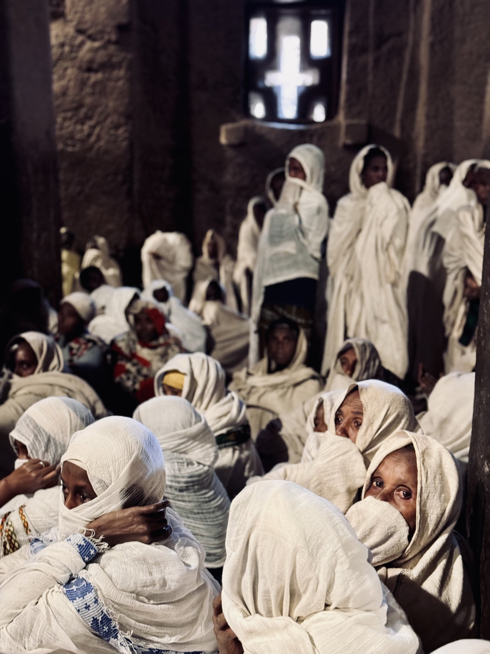 White-robed pilgrims gathered at an ancient stone church