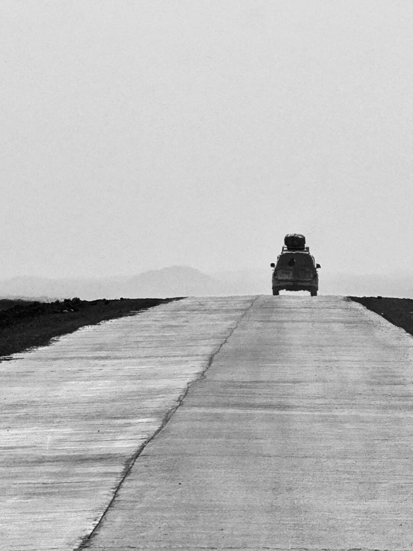 Lone road disappearing into fog, black and white