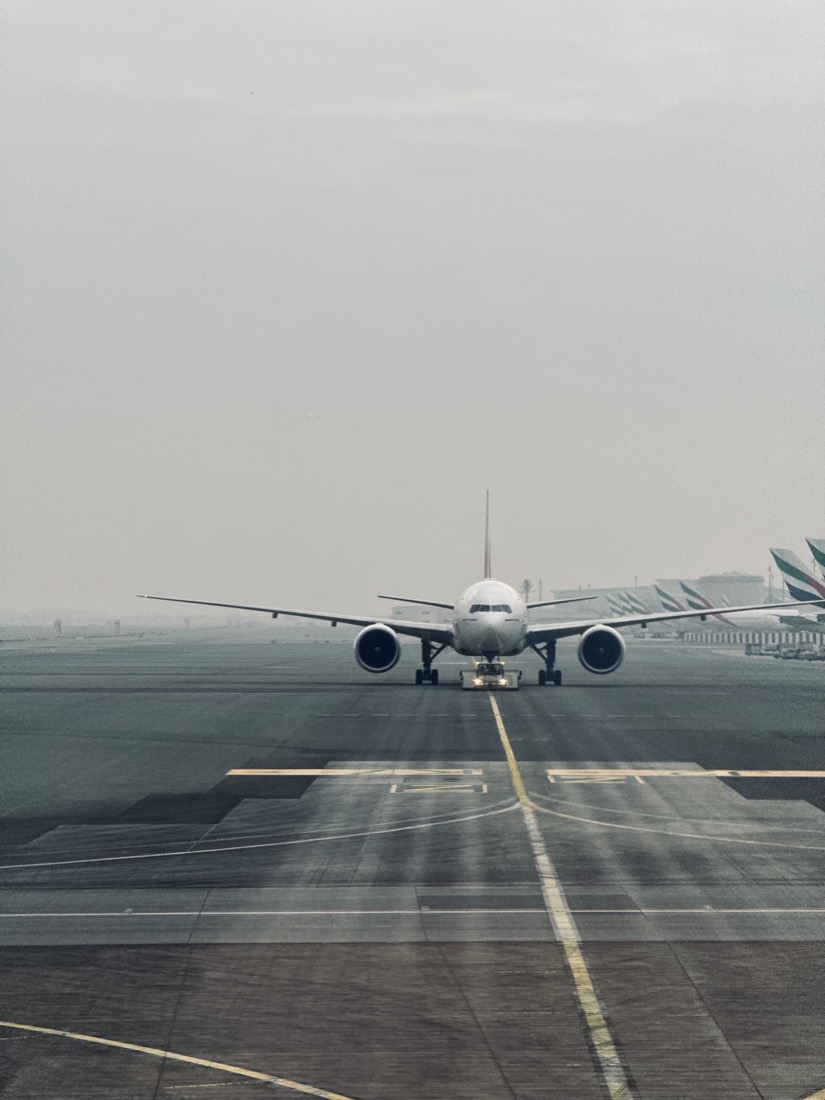 Airliner landing over a runway in pale haze