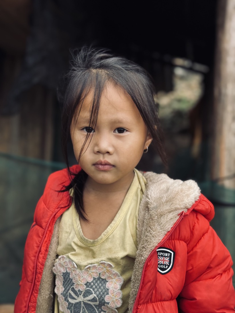 Young girl in a red jacket looking into the camera