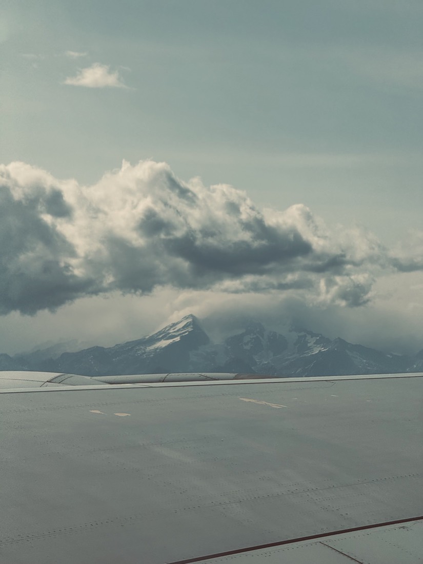 Clouds pouring over a mountain ridge seen from above