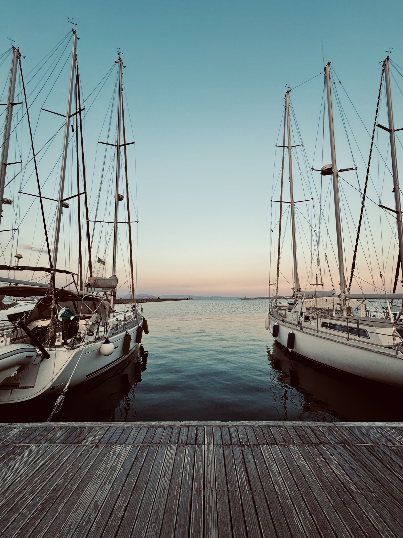 Masts of tall ships moored in a harbour at dusk
