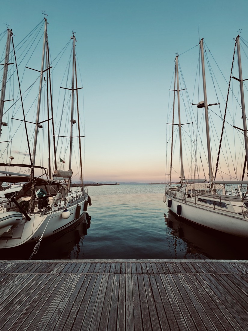 Masts of tall ships moored in a harbour at dusk