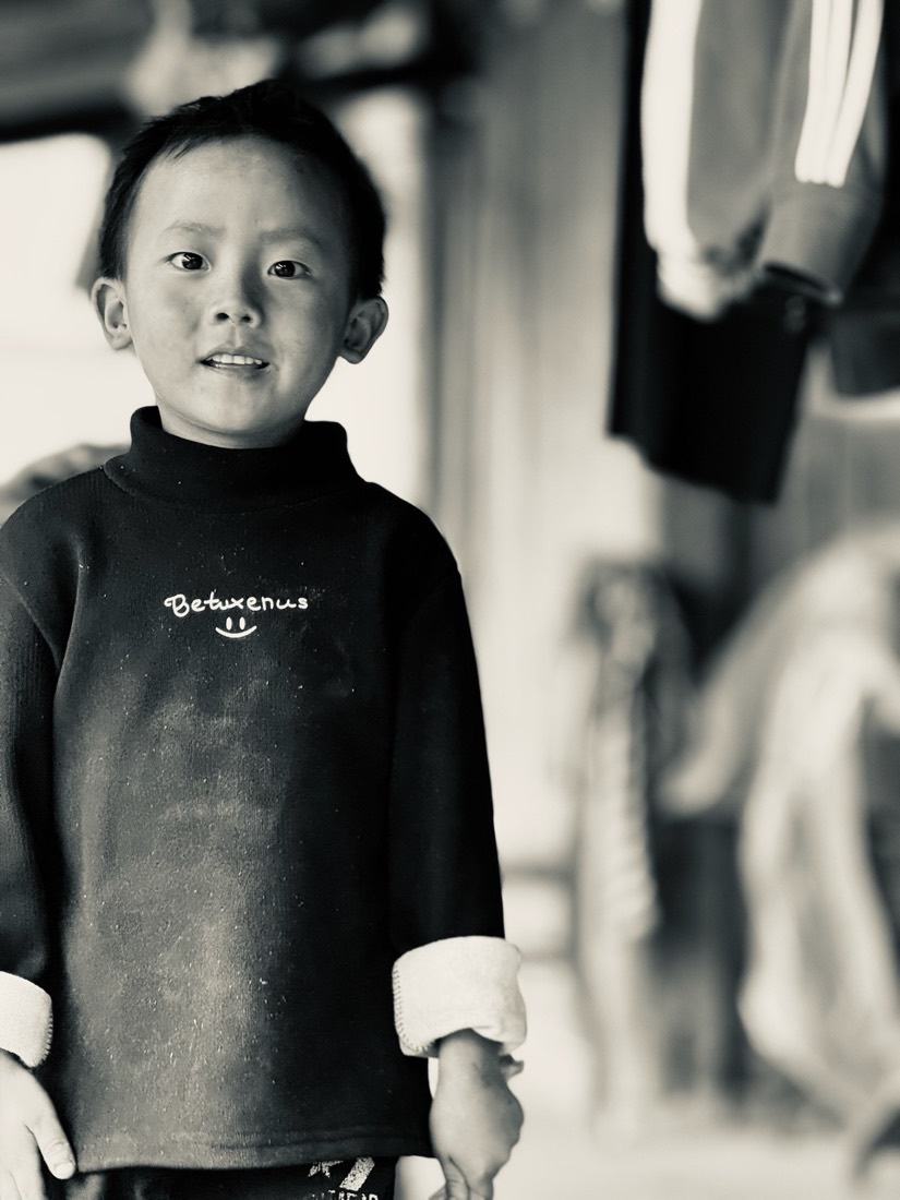 Young boy in a dark sweater, black and white portrait
